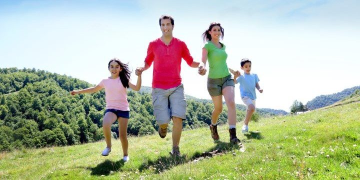Happy family enjoying and running together in the mountains